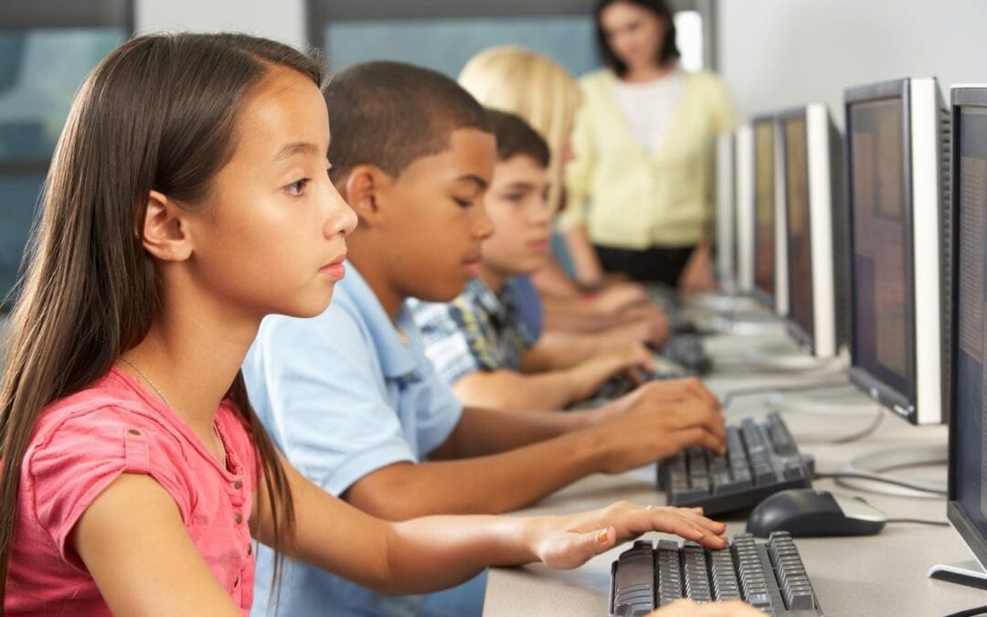 Elementary Students Working At Computers In Classroom